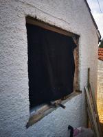 Removing a failed wooden window in a rendered gable