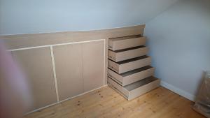 Eaves storage of loft conversion with bank of handleless drawers