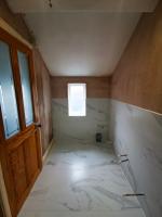 Ensuite bathroom formed where a WC once was, tiled ready for second fix plumbing