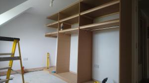 Open walk-in wardrobe room with hanging, shoe shelves and make-up counter