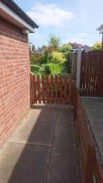 Replacement garden gate formed from a picket fence panel