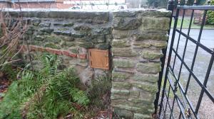 Oak postbox built into garden wall