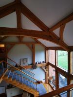 Cruck ceiling timbers of an oak constructed building with glass and oak balustrade