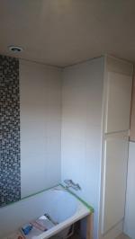 Bathroom plastered and bath fitted, undergoing tiling, with white gloss boiler cupboard