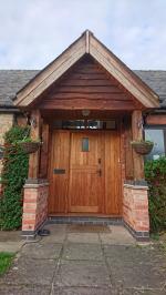 Pine door and panel set with tiled porch canopy and waney board gable
