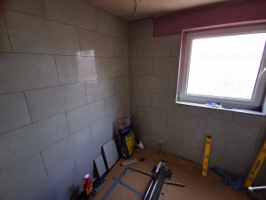 Bathroom being refurbished, fitting wall tiles