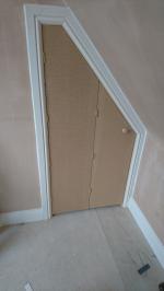 Cupboard with bi-folding door built into the pitch of a loft conversion