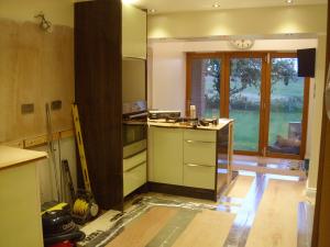 Cream gloss kitchen with wenge worktops under installation