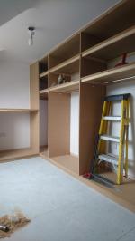 Open walk-in wardrobe room with hanging, shoe shelves and make-up counter