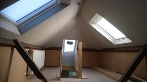Loft converted into childrens playroom with storage cupboards all round