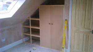 Wardrobe and storage built into the roof pitch of a loft