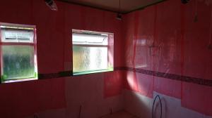 Bathroom and toilet knocked together to form larger room, walls tiled and protected whilst ceiling is painted