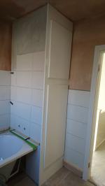 Bathroom plastered and bath fitted, undergoing tiling, with white gloss boiler cupboard