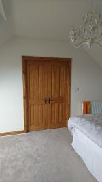 Dark stained knotty pine four panel doors in loft conversion