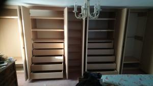 Long bank of basic shaker style wardrobes with integral handleless drawers