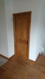 Dark stained knotty pine four panel door in loft conversion