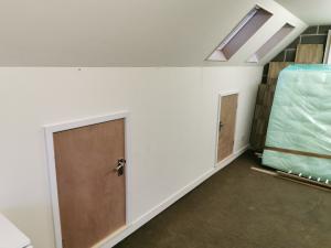 Velux windows installed in a garage loft space, access doorways formed to use eaves for storage