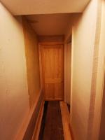 Hallway formed where staircase once stood with heating-services cupboard formed at the end