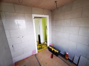 Bathroom being refurbished, fitting wall tiles