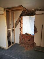 Previously sealed doorway being reopened, revealing original oak lintel